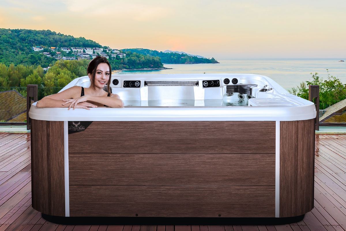 Woman relaxing alone in a hot tub overlooking the ocean at sunset