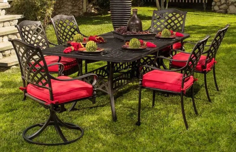 Hanamint Berkshire cast-aluminum dining set with six chairs and red cushions, set with plates and a centerpiece