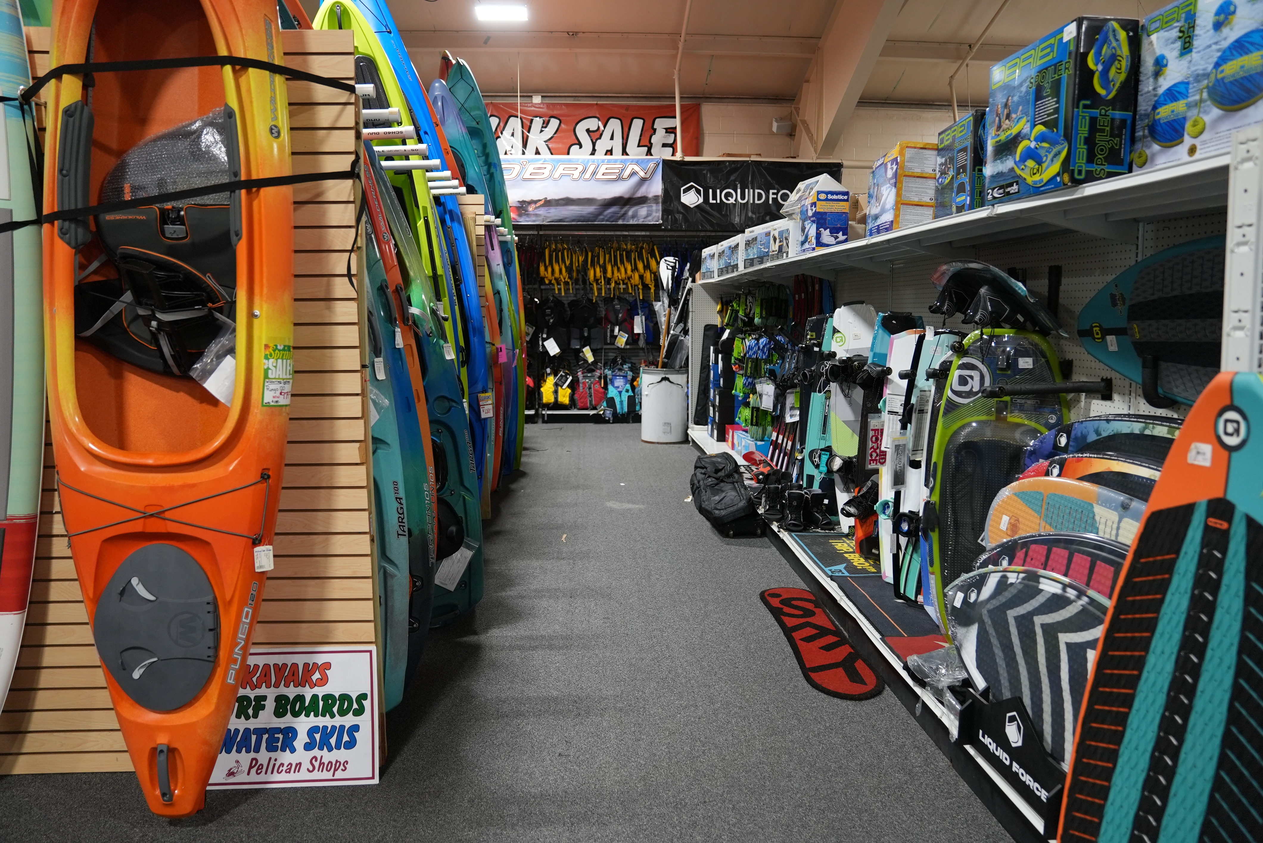 Pelican Shops watersports department&mdash;kayaks, stand-up paddleboards, water skis, wakeboards and life vests on the showroom floor